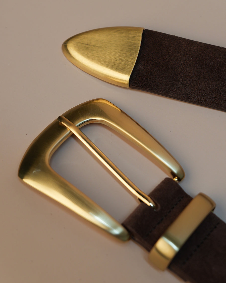 Brown belt with gold buckle on a beige background