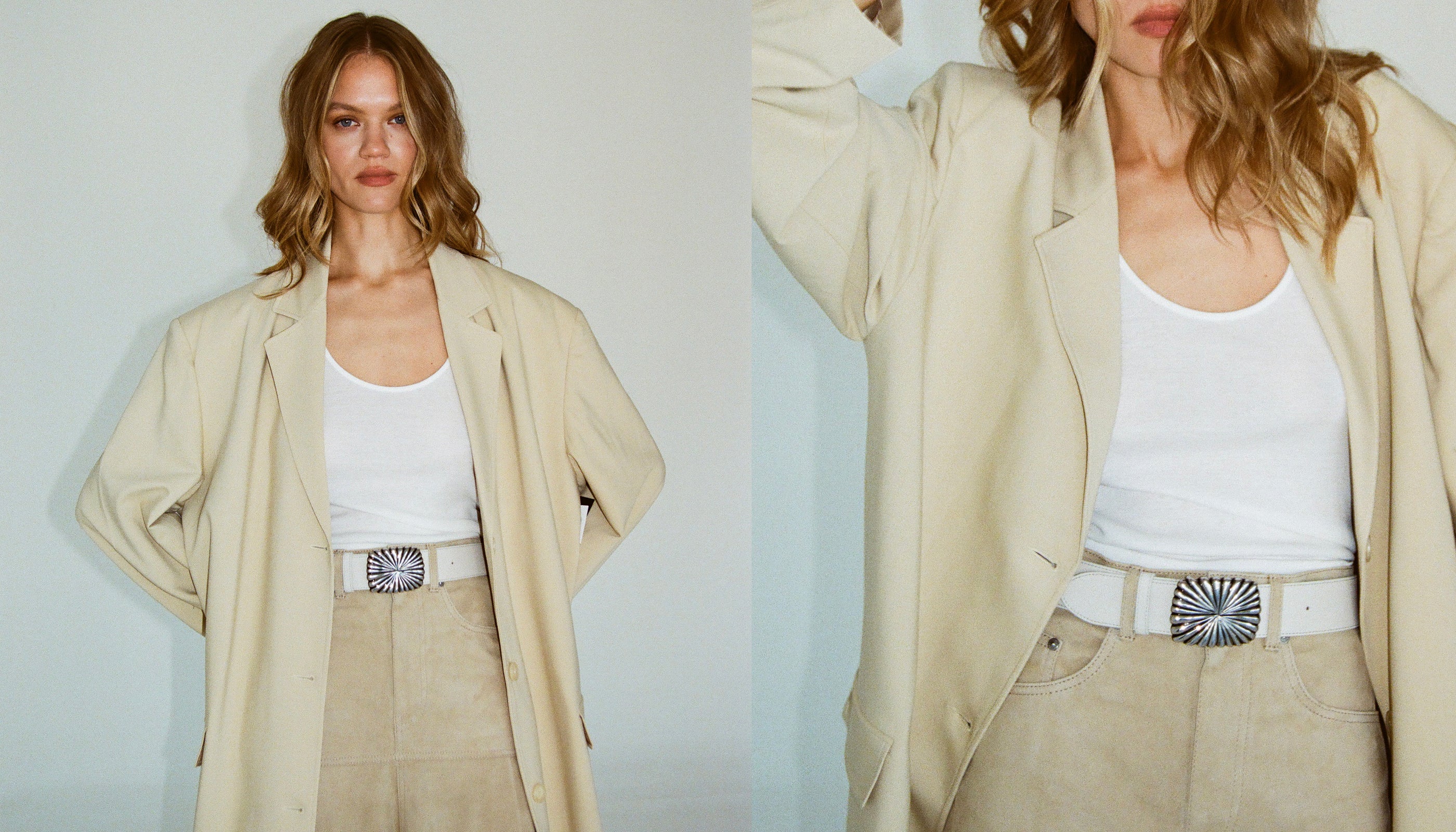 Woman wearing a beige trench coat over a white top with a belt, against a plain background