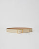 Light sand colored patent leather belt with croc-embossed finish. Fastens with simple gold triangle shaped buckle.